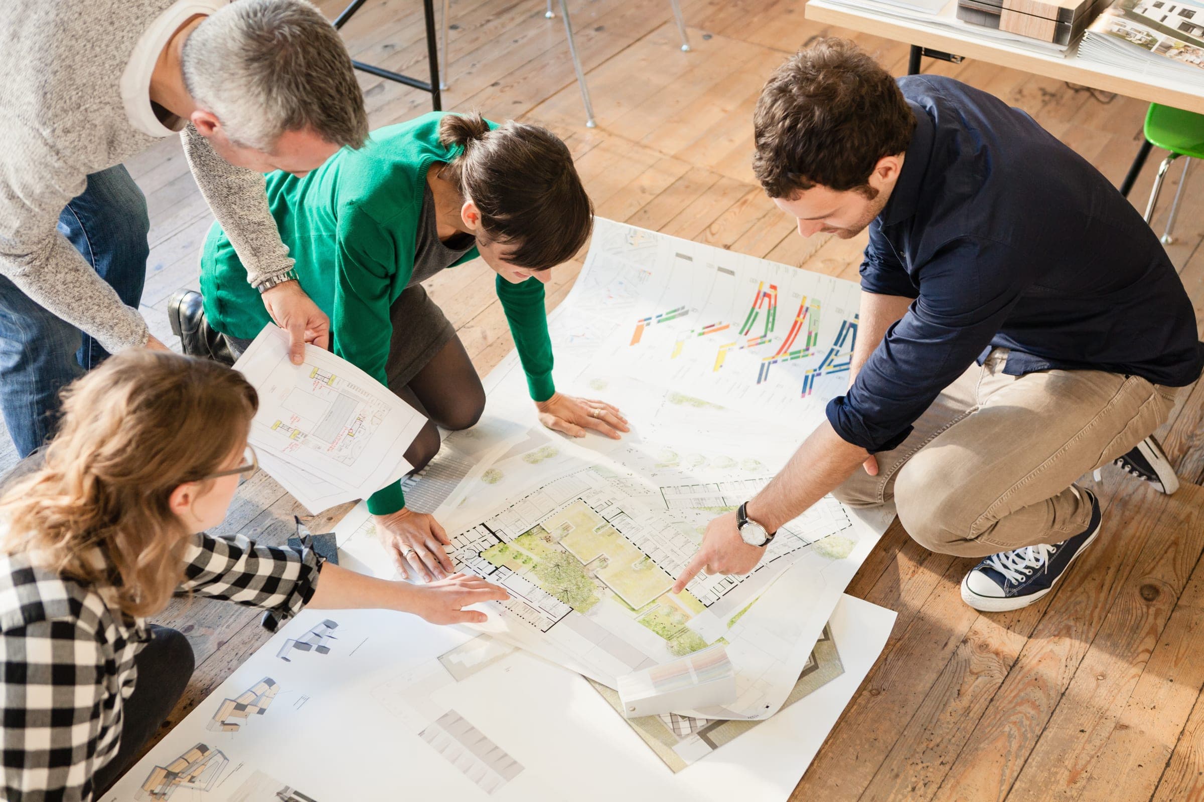 Hands reviewing a route map and notes during an experience planning session.